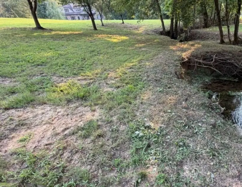 Eroded, undercut creek bank before repair